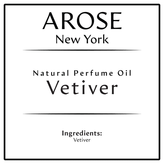 10ml roll-on bottle of Arose NY Vetiver Perfume Oil styled with vetiver roots and greenery – fresh, earthy, unisex scent in alcohol-free formula.